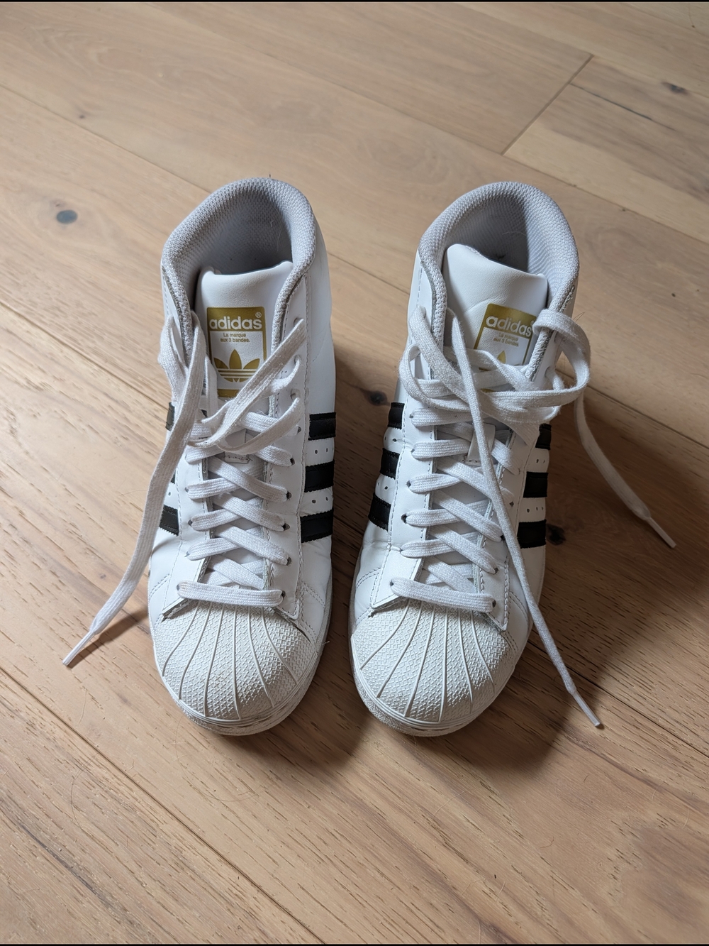 adidas Women’s White High-Top Sneakers with Black Stripes and Gold Tongue Logo